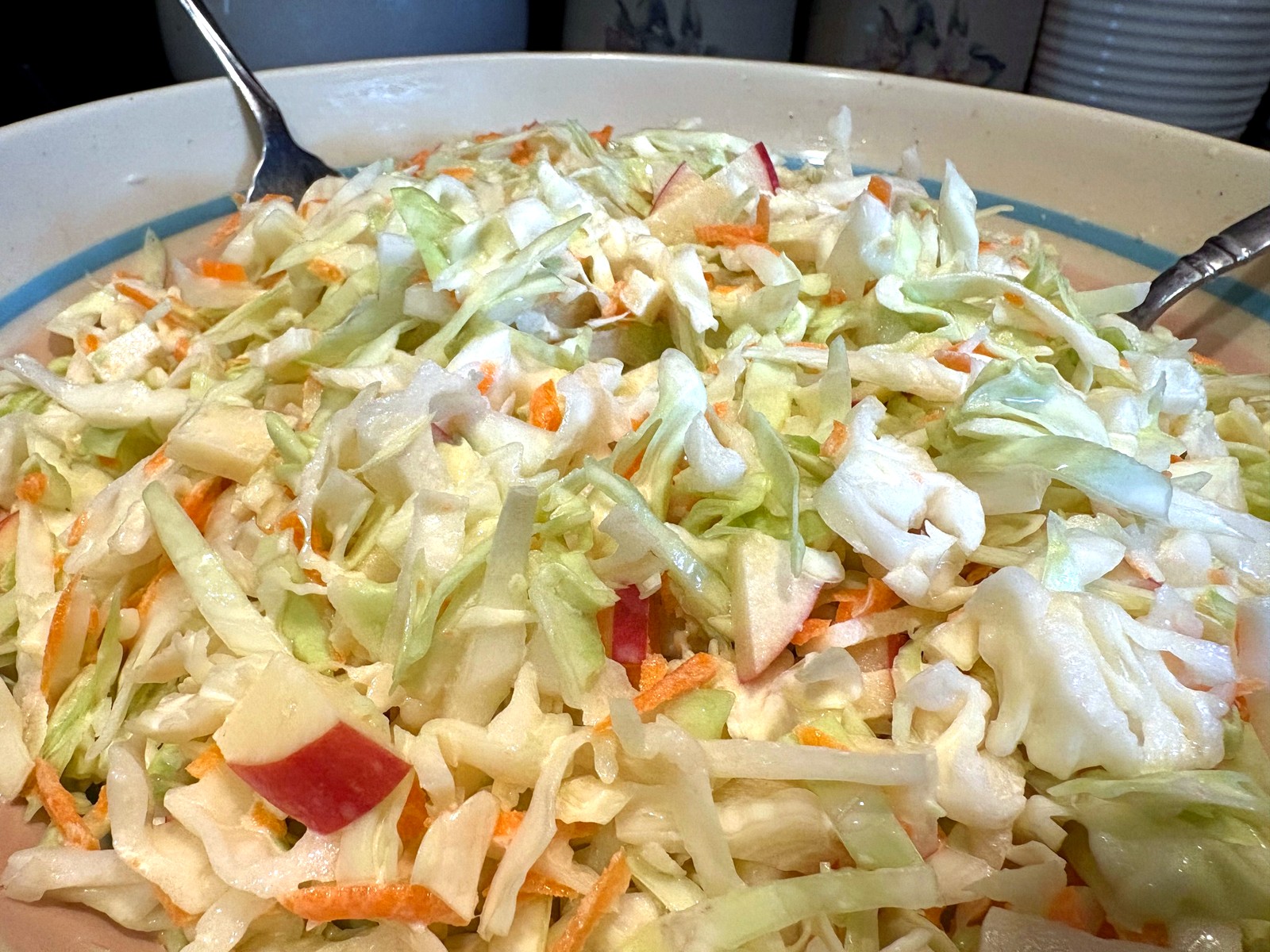 Close-up of creamy cabbage-apple-carrot slaw with crisp textures.