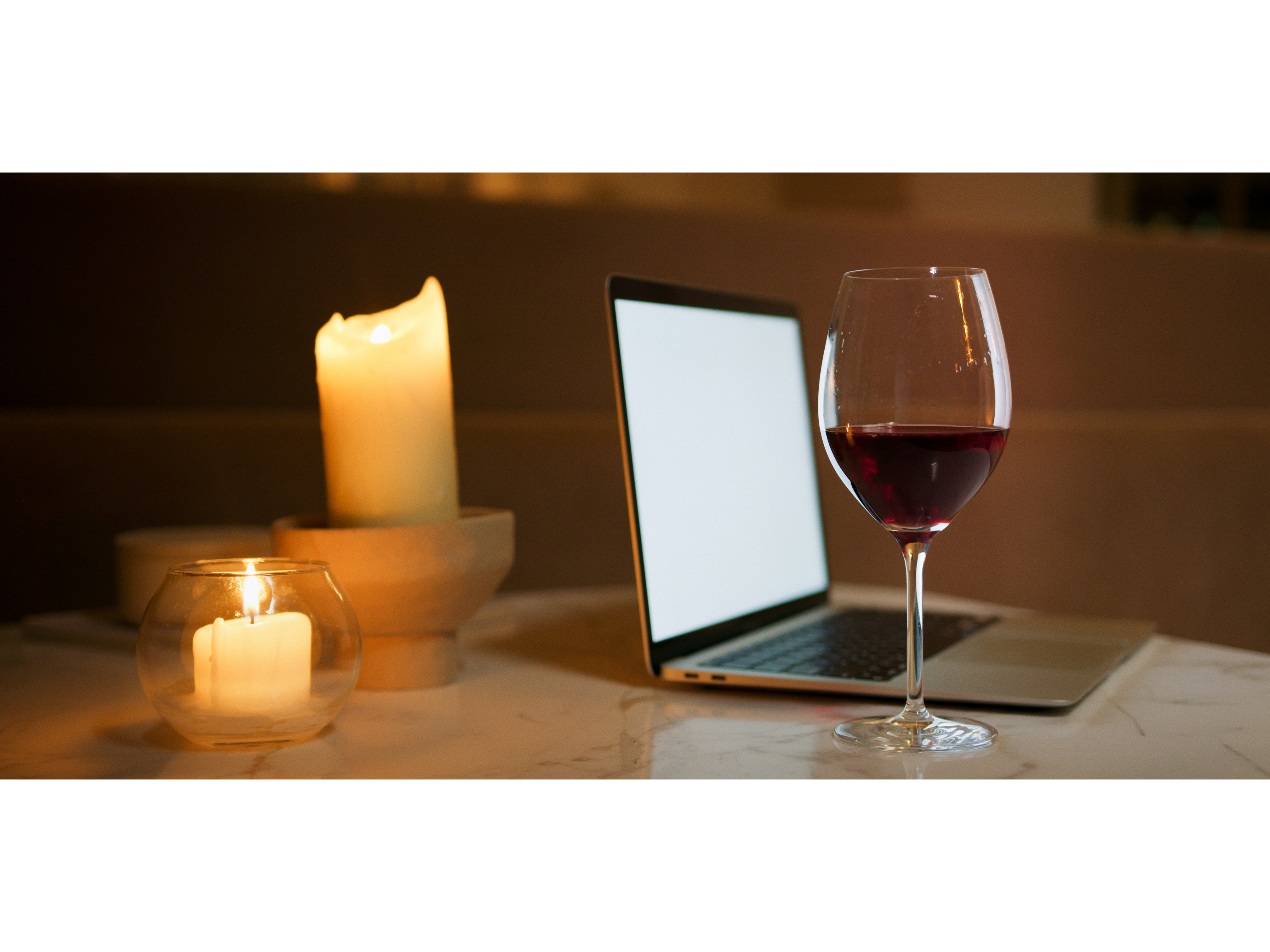 Late-night creative work at a quiet desk, hands typing beside a softly glowing candle during a season of reflection and intentional building.
